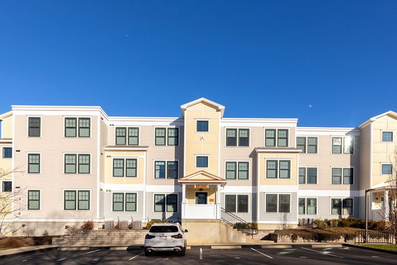Front view of a multi-story residential building with multiple windows and a central entrance.