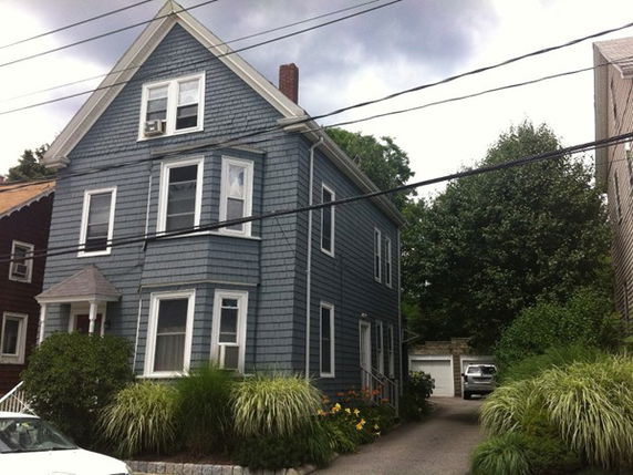 Front view of a two-story house with gray siding.