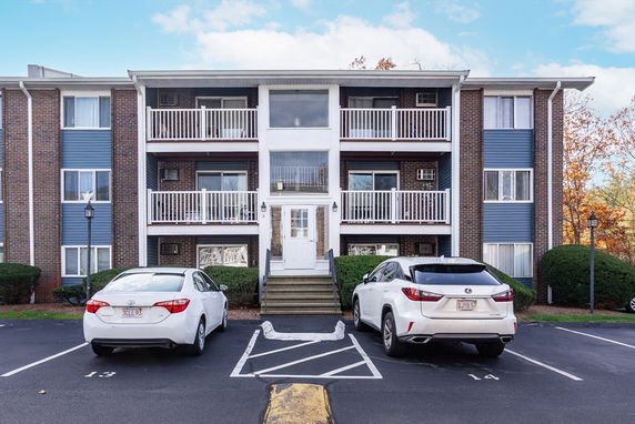 Front view of a three-story apartment building with balconies.