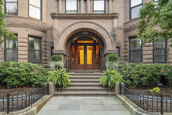 Front view of a historic stone building with intricate architectural details and an arched entrance.