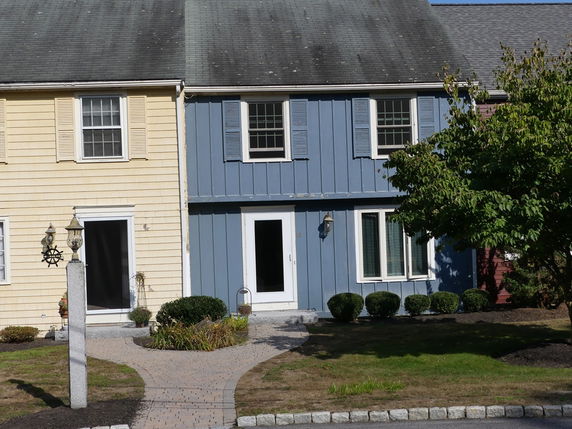 Front view of a two-story house with blue siding and a central entrance.