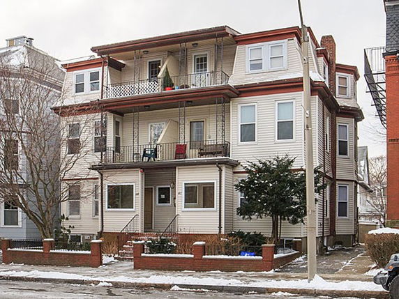 Front view of a multi-story residential building with balconies.