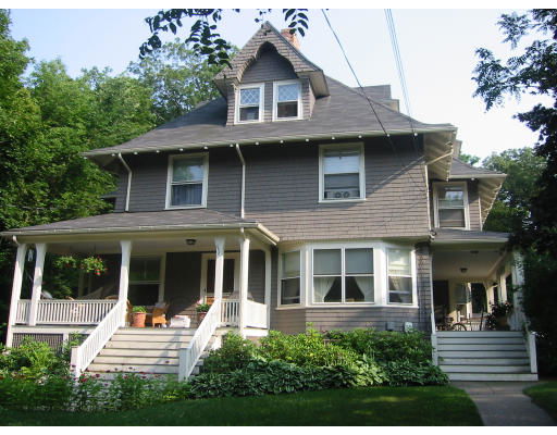 Front view of a two-story house with a gabled roof and a covered porch.