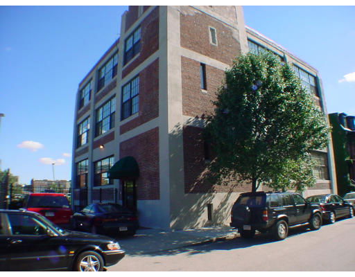 Front view of a multi-story brick building with large windows.