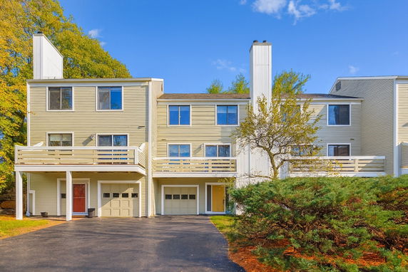 Front view of a multi-story townhouse with attached garages.