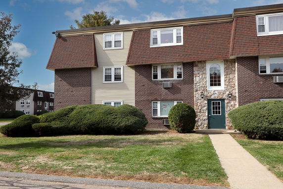 Front view of a multi-story residential building with a brick and stone facade.