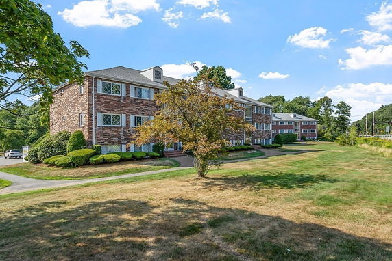 Front view of a multi-story brick building with a path leading to it.
