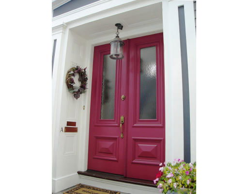 Front view of an entrance with double magenta doors and a lantern above.