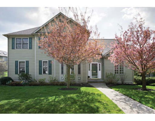 Front view of a two-story house with large windows and trees in front.