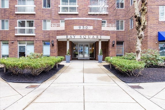 Front view of a multi-story brick building with entrance awning labeled 'Bay Square'.