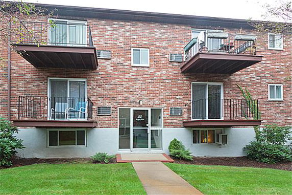Front view of a brick apartment building with balconies.