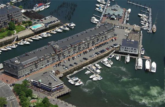 Aerial view of a waterfront complex with multiple boats docked around it.