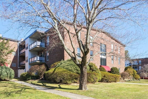 Front view of a brick apartment building with balconies.