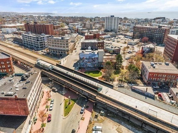 Aerial view of a cityscape with buildings, railroad tracks, and streets.