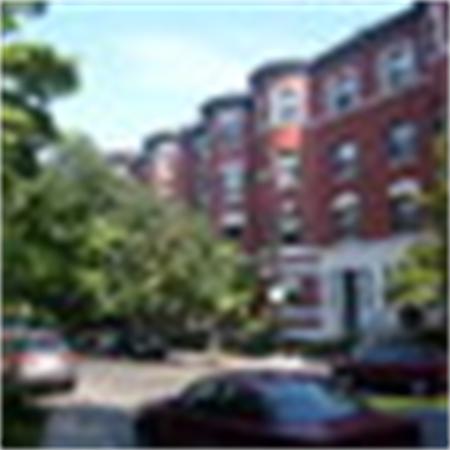 Front view of a multi-story brick building with arched windows.