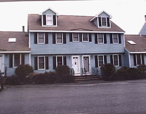 Front view of a two-story house with gable roofs and multiple entrances.
