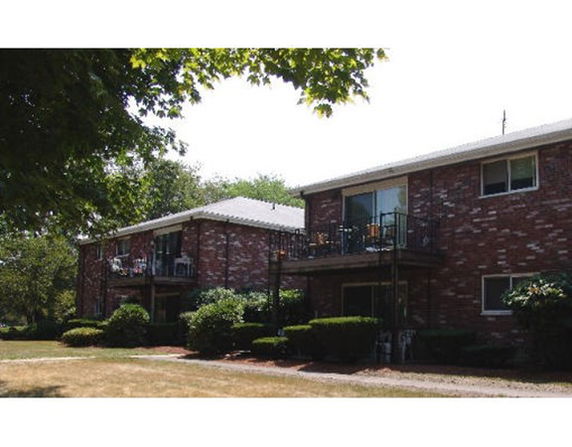 Front view of a two-story brick apartment building with balconies.
