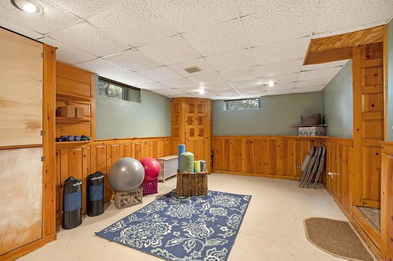 Indoor space with exercise equipment and wall paneling.