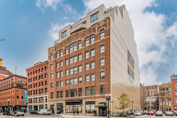 Front view of a multi-story brick building in an urban area.