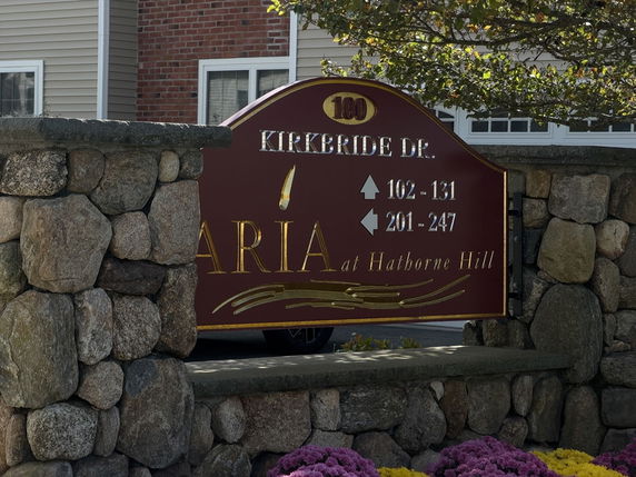 Stone wall with a directional sign for a residential complex.