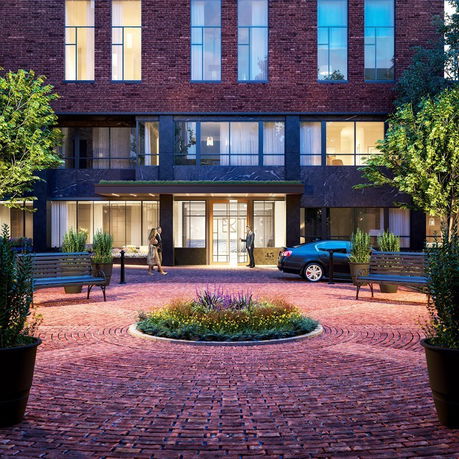 Front view of a multi-story brick building with large windows and entrance.