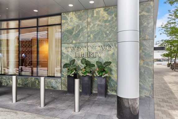 Entrance of a building labeled 'Twenty Two Liberty' with glass windows and a stone facade.