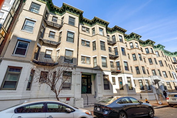 Front view of a multi-story apartment building with balconies.