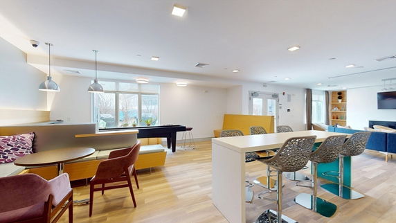 Interior of a recreation area with seating and a pool table.