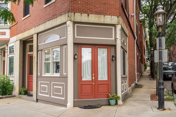 Front view of a building with red double doors and decorative window trim.