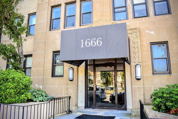 Front view of a building entrance with a canopy displaying the number 1666.