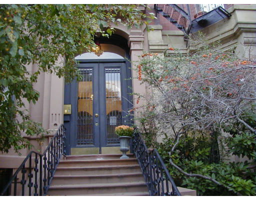 Front view of a building entrance with a staircase and decorative railing.