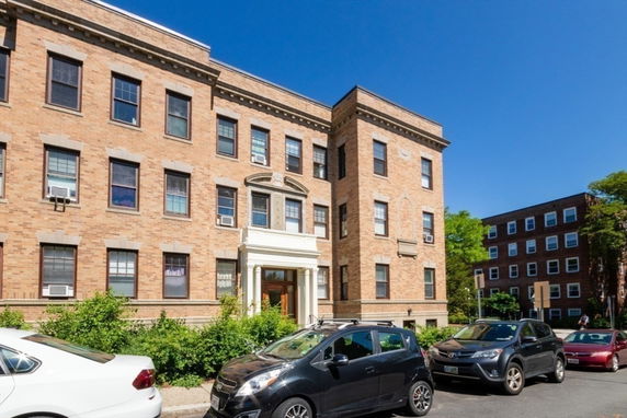 Front view of a multi-story brick apartment building.