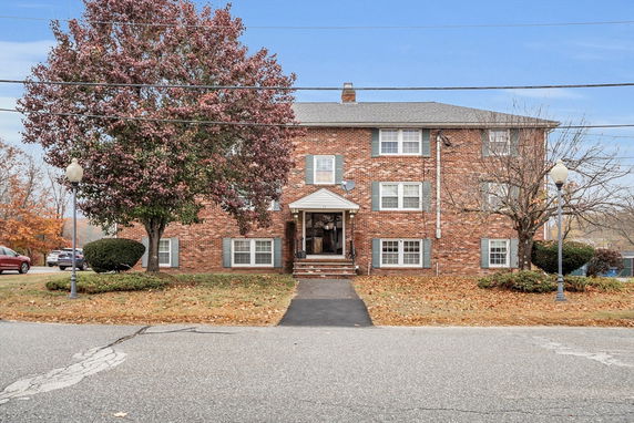 Front view of a two-story brick apartment building with a central entrance.