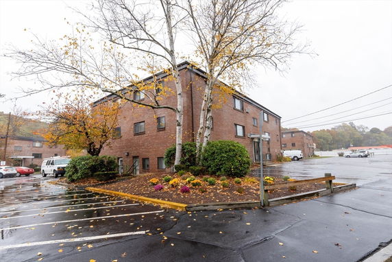 Front view of a three-story brick building with multiple windows and a side entrance.