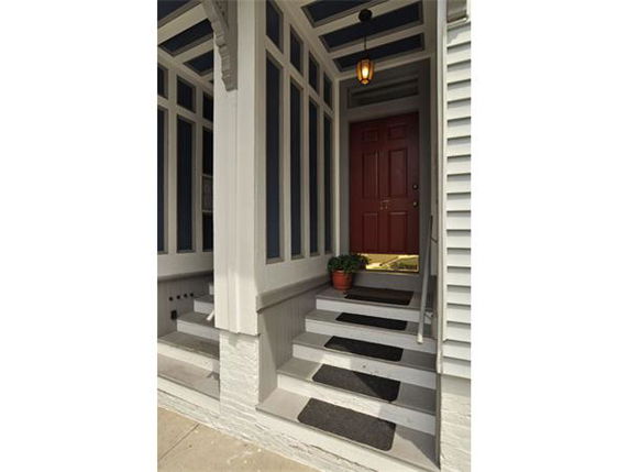 Front view of a house entrance with steps leading to a red door.