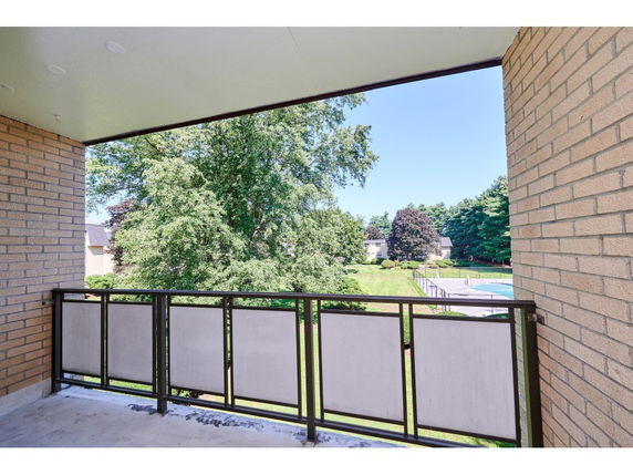 View from a balcony overlooking outdoor area and swimming pool.