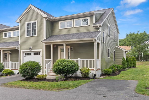 Front view of a two-story house with an attached garage and a front porch.