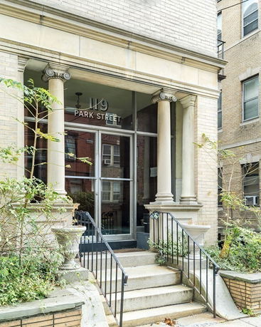 Front view of a building entrance with columns and steps.
