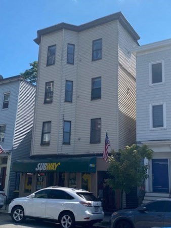 Front view of a multi-story building with a Subway store on the ground floor.