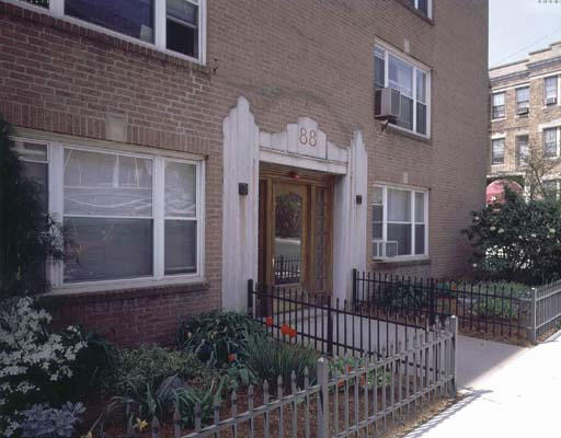 Front view of a brick building with multiple windows and a decorative entrance.