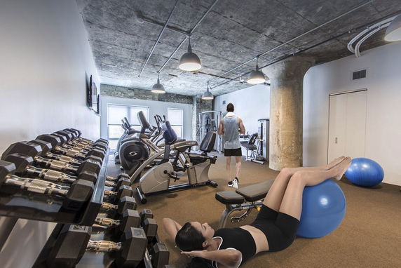 Interior view of a fitness room with exercise equipment and weights.