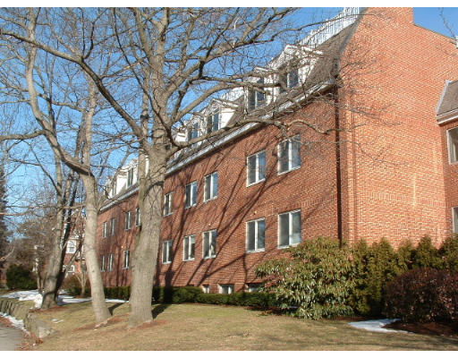 Side view of a multi-story brick building with dormer windows.