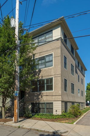 Front view of a multi-story residential building with large windows.