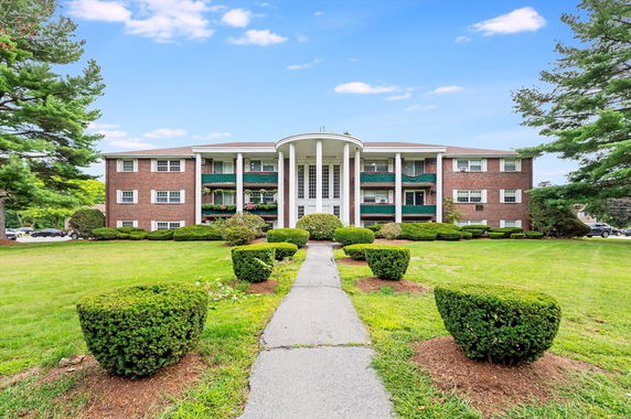 Front view of a three-story building with a symmetrical design and large columns.