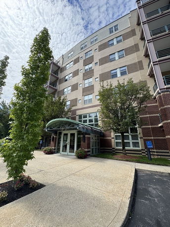 Front view of a multi-story building with a glass entrance.