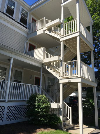 Front view of a multi-story building with external staircase.