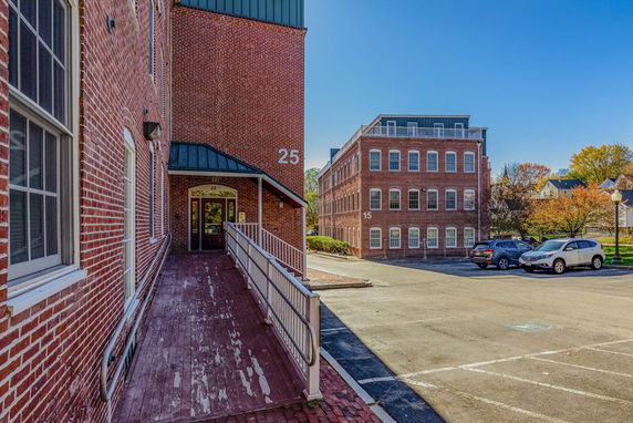 Front view of a brick building with multiple floors and large windows.