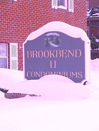 Front view of a building with a sign reading 'Brookbend II Condominiums'.
