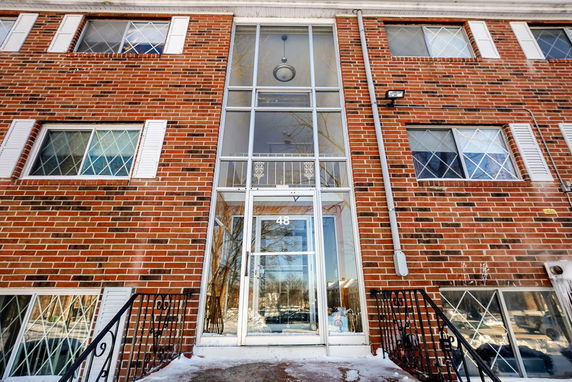 Front view of a multi-story brick building with a central glass entryway.