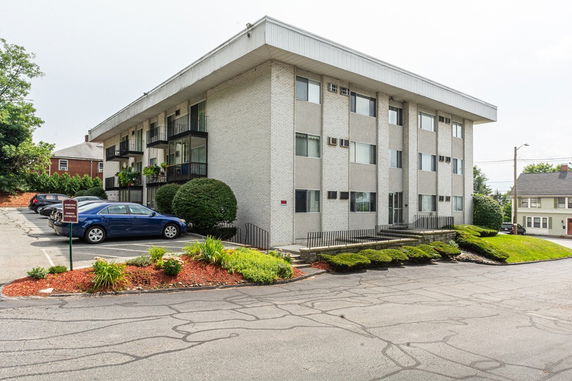 Front view of a three-story apartment building with balconies.
